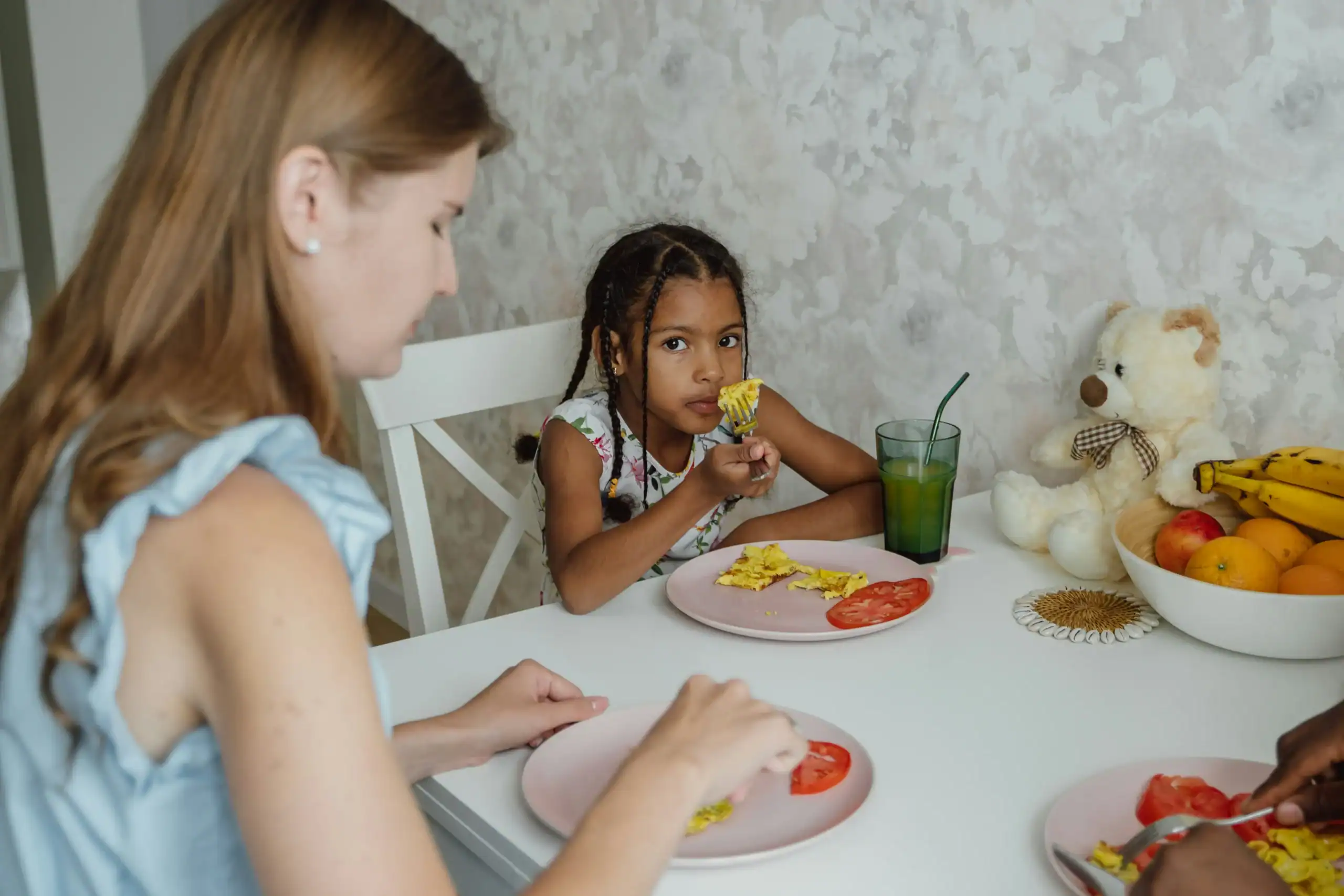 Young girl inspecting food during breakfast, showing possible hesitation due to food texture sensitivity Young girl inspecting food during breakfast, showing possible hesitation due to food texture sensitivity