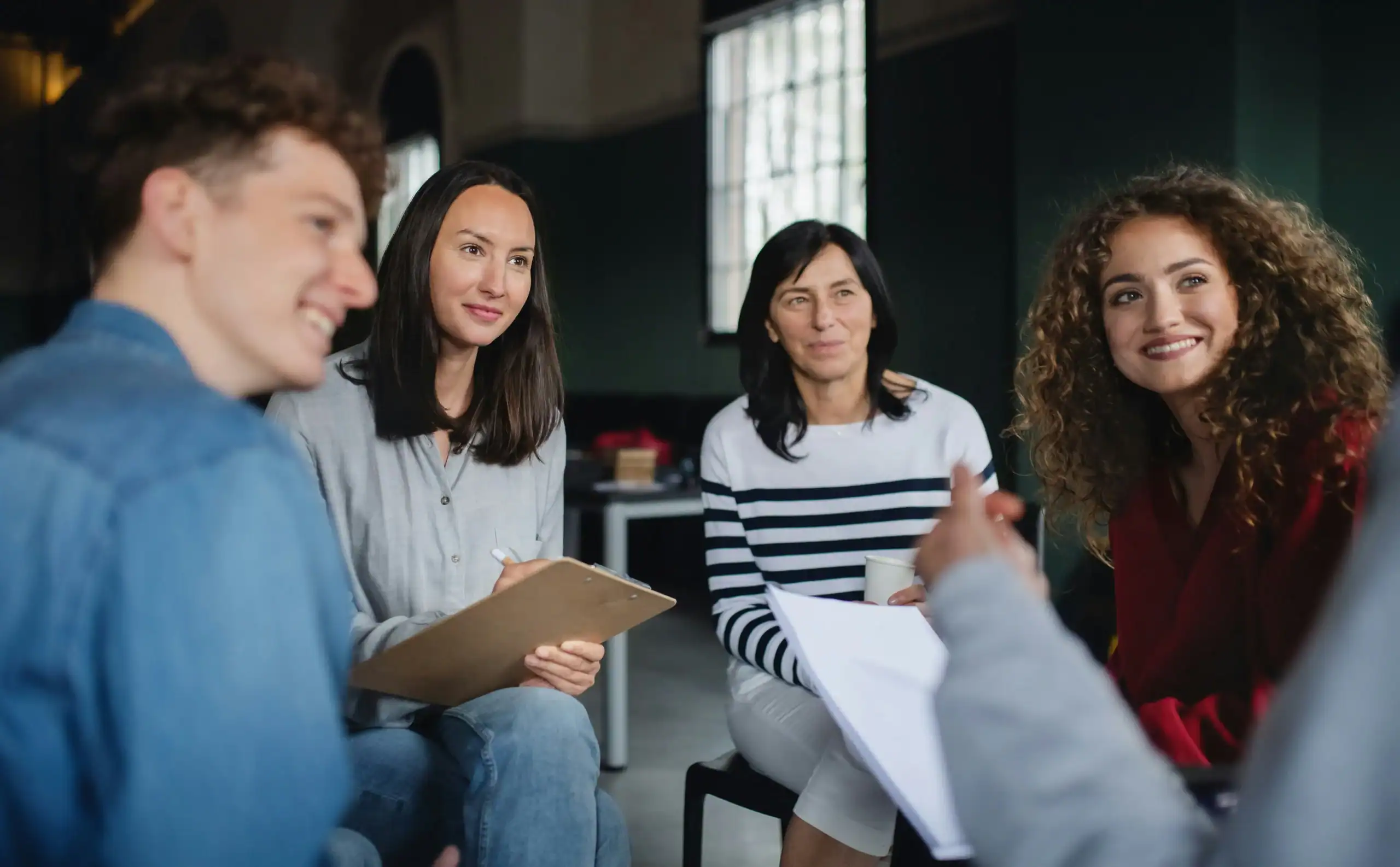 Support group of adults in discussion, showing collaborative care in special needs group homes Support group of adults in discussion, showing collaborative care in special needs group homes