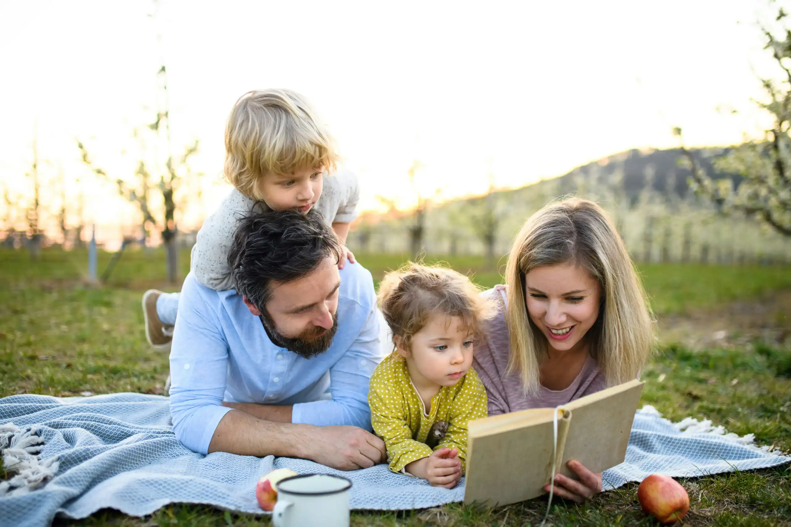 Family reading outdoors, highlighting early hyperlexia traits and support that benefit adults Family reading outdoors, highlighting early hyperlexia traits and support that benefit adults