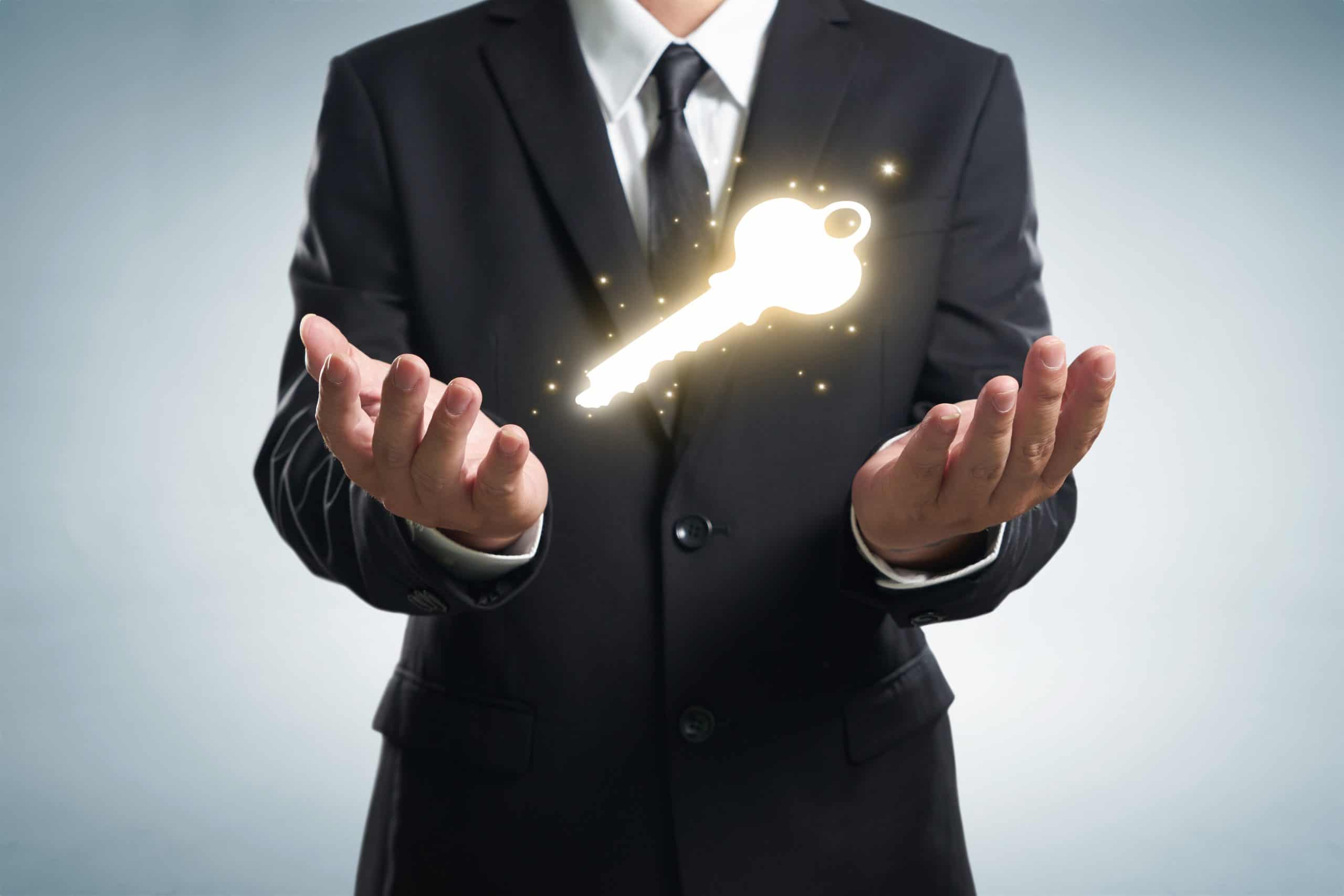 Close up of businessman hand showing key to success Close up of businessman hand showing key to success