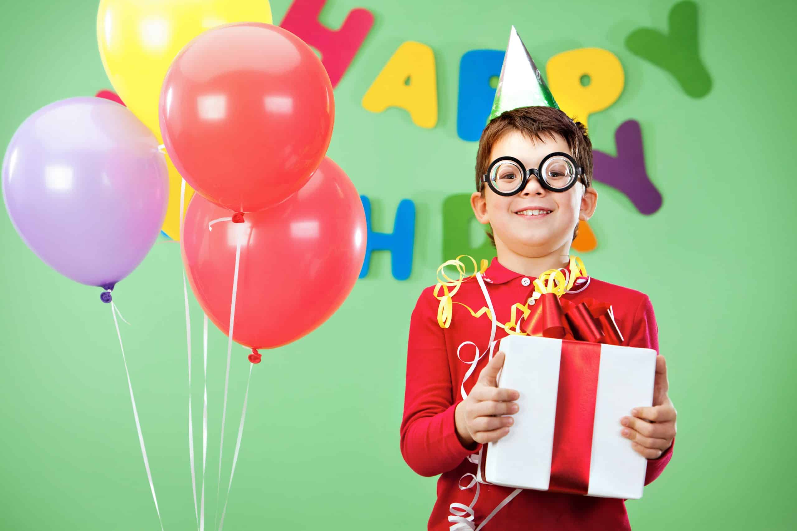 Happy lad Portrait of happy lad in funny eyeglasses on birthday party with giftbox