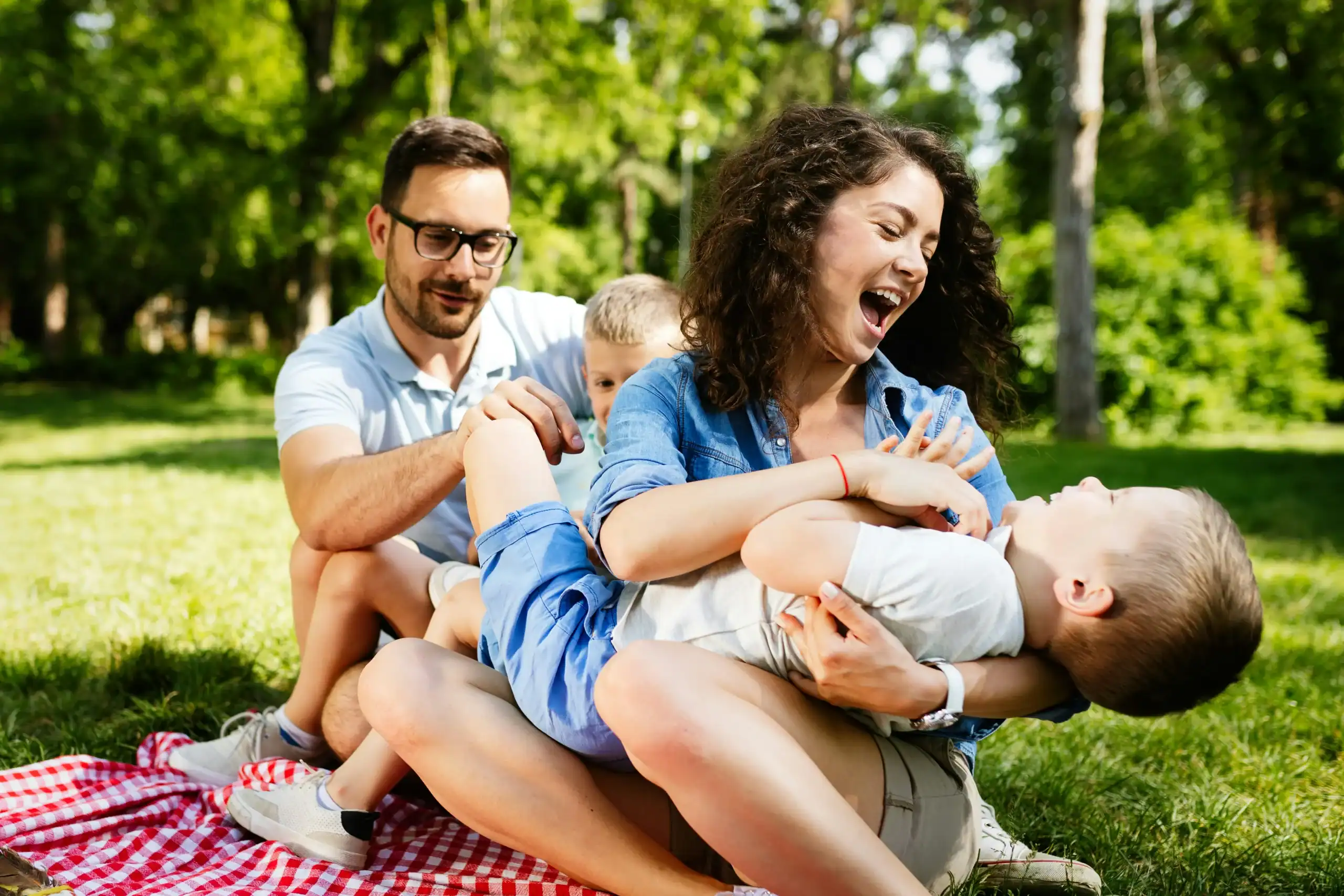 two parents in the park with kids portraying co-parenting in divorce settlement with special needs child