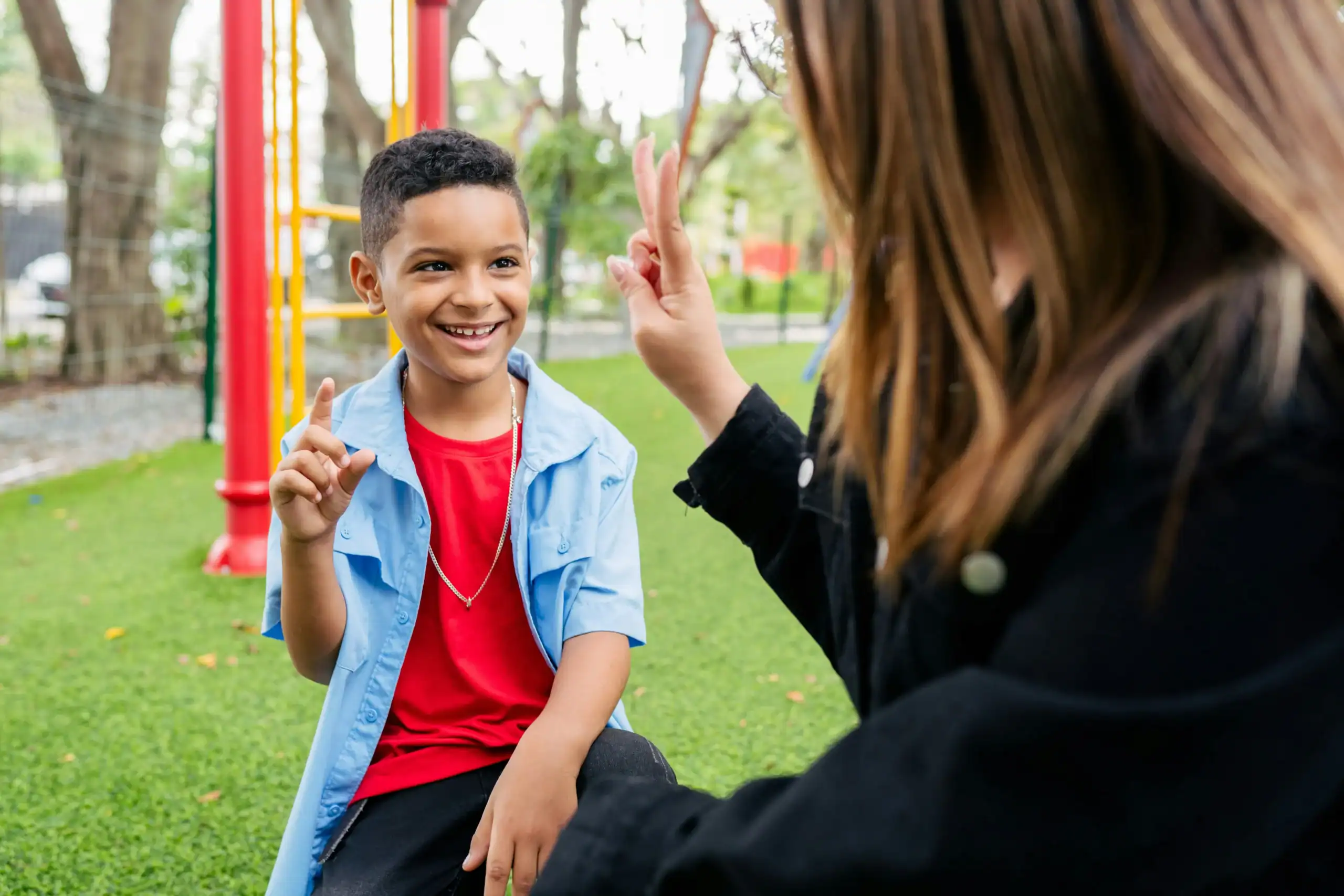 Child and therapist using sign language, support for bilateral hearing loss