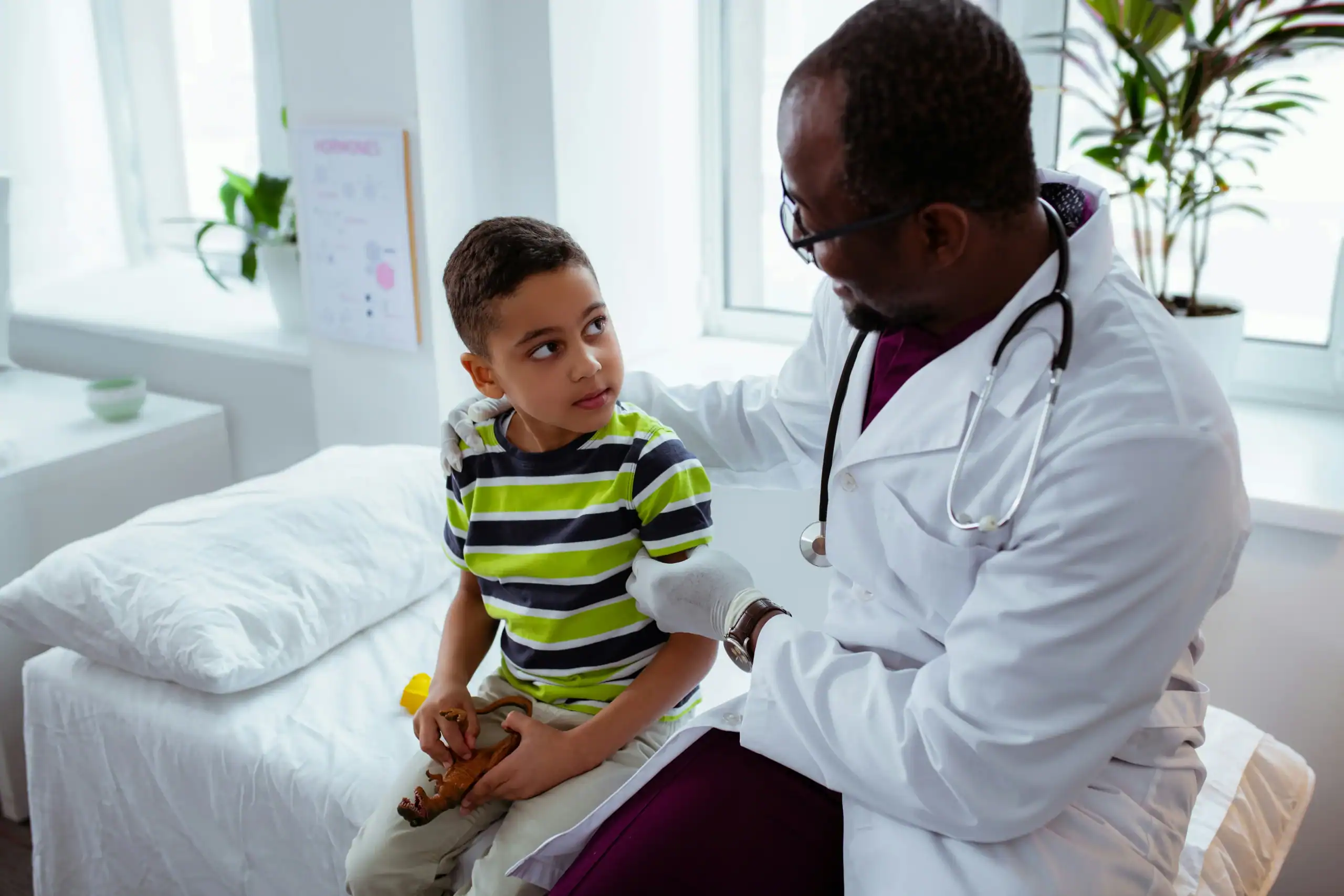 Doctor comforting boy with rett syndrome and autism during checkup Doctor comforting boy with rett syndrome and autism during checkup