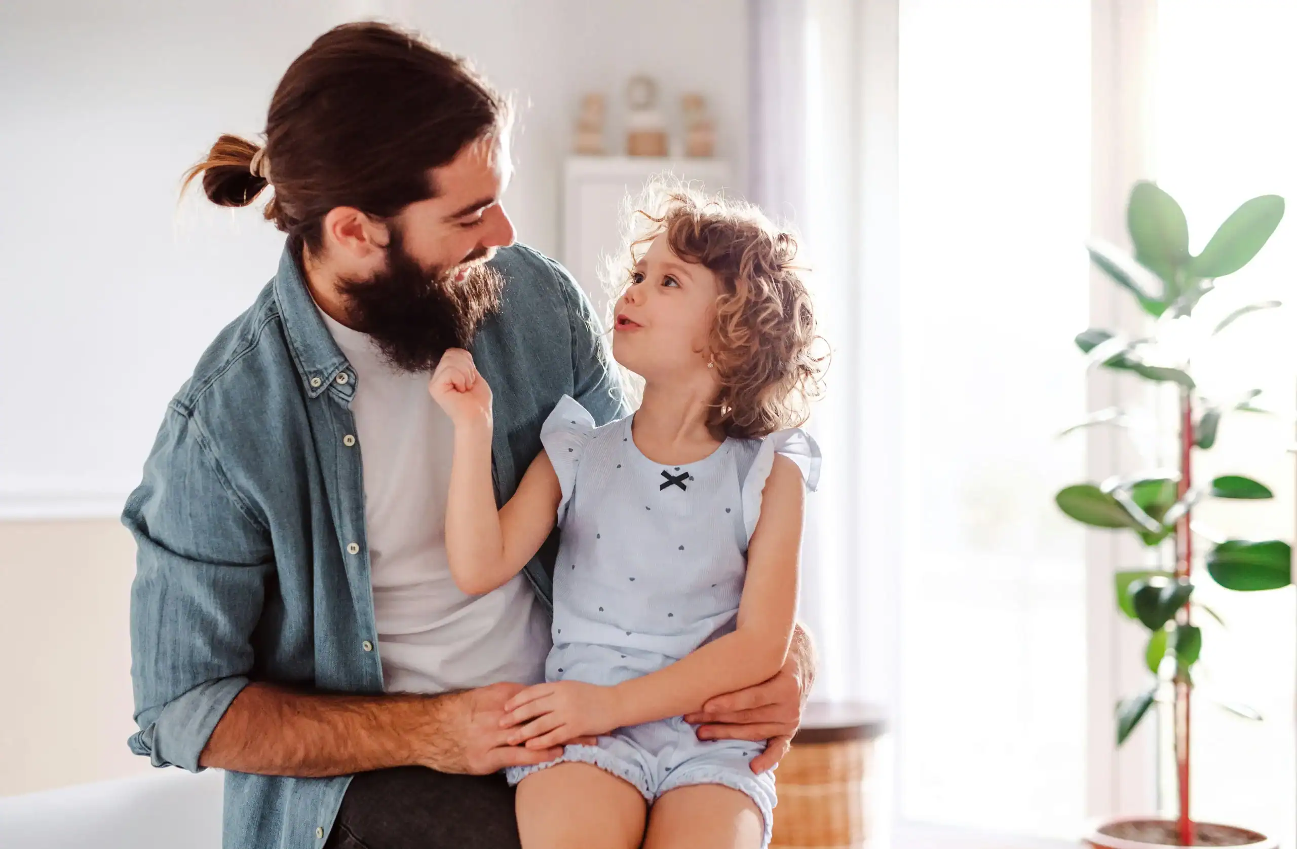 Father supporting young child with speech delay through positive communication at home