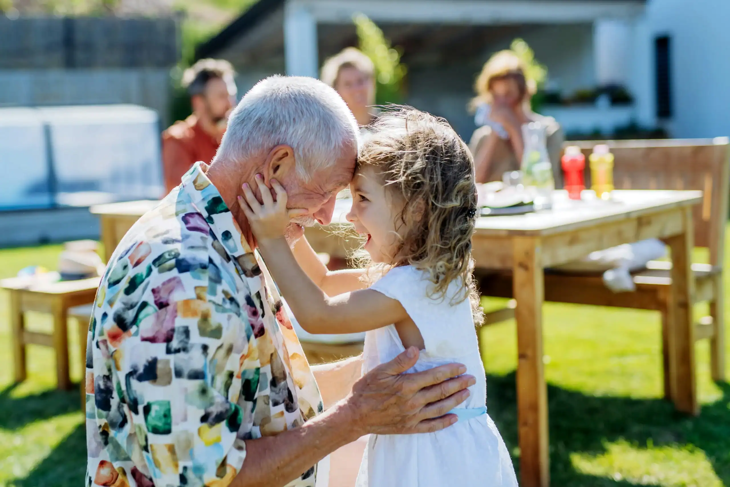 Grandfather smiling with granddaughter outdoors Grandfather smiling with granddaughter outdoors