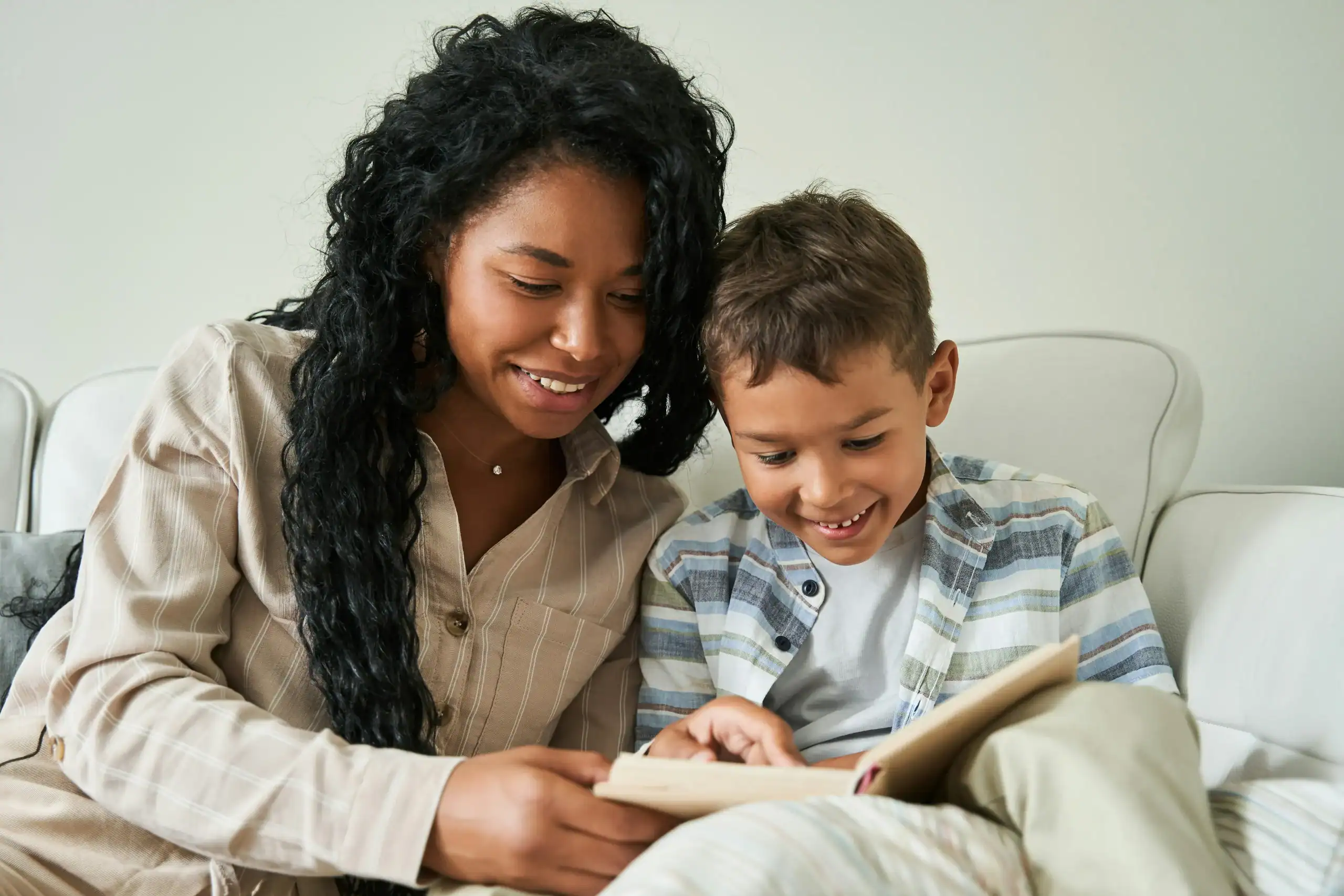 Mother reading with son at home, helping manage hyperlexia symptoms with support.