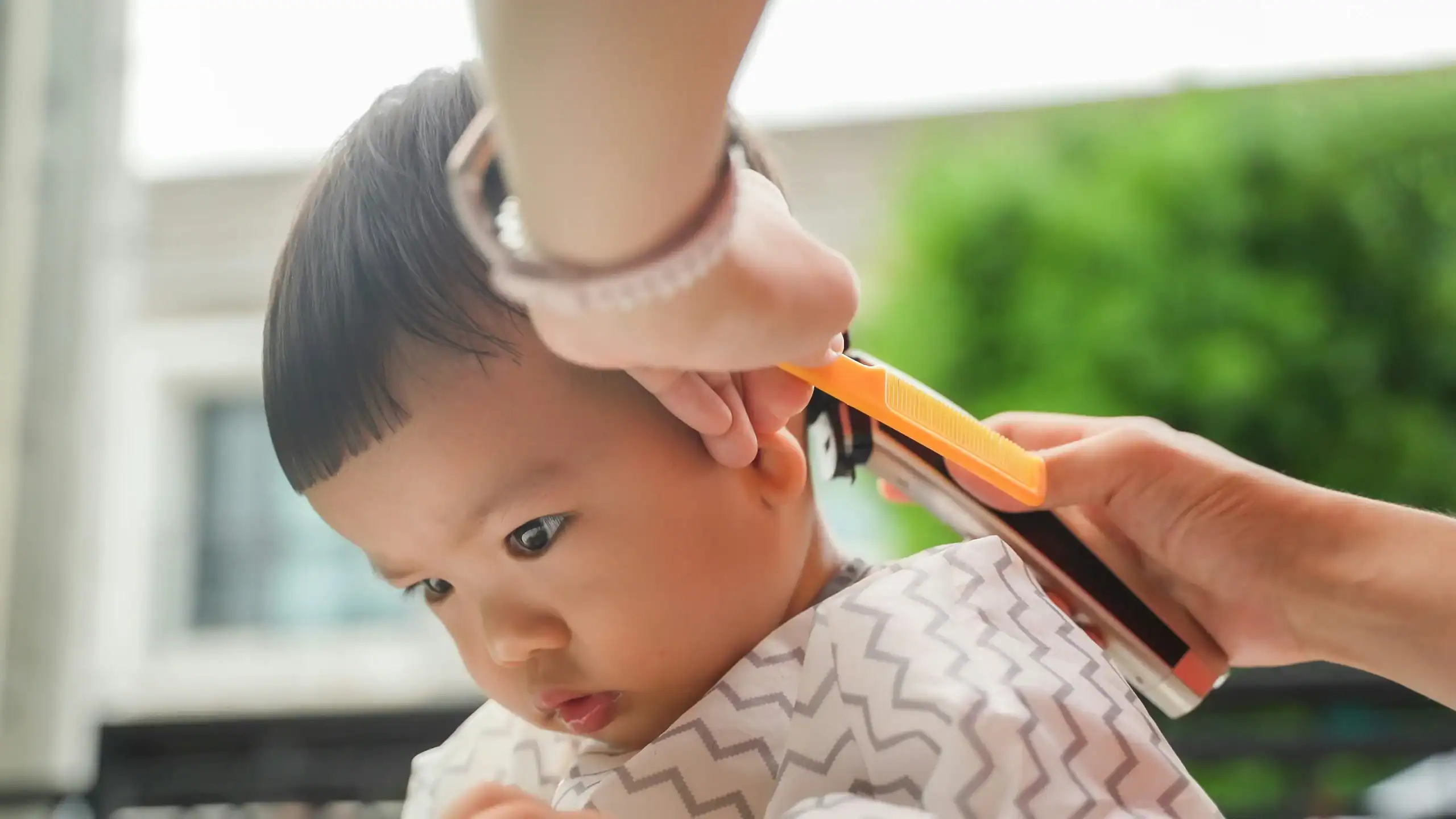 Toddler receiving first trim with scissors, careful approach to special needs haircuts.