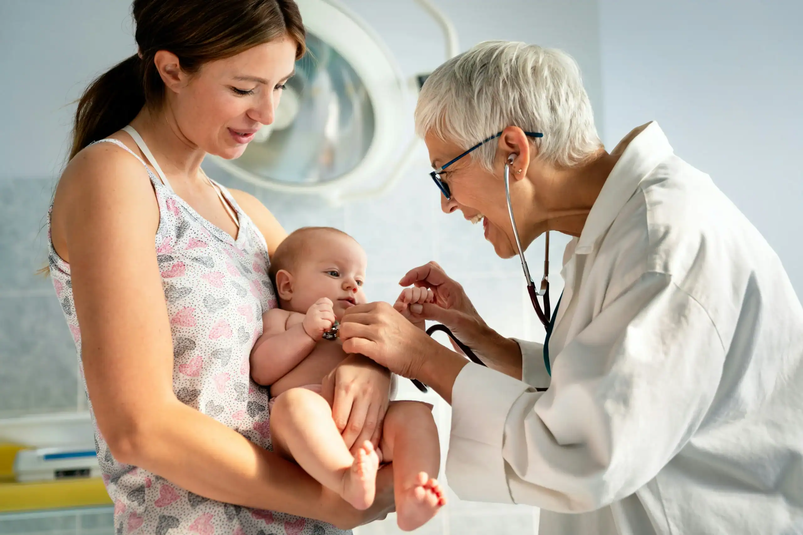 Doctor examining baby for tongue and lip tie during checkup