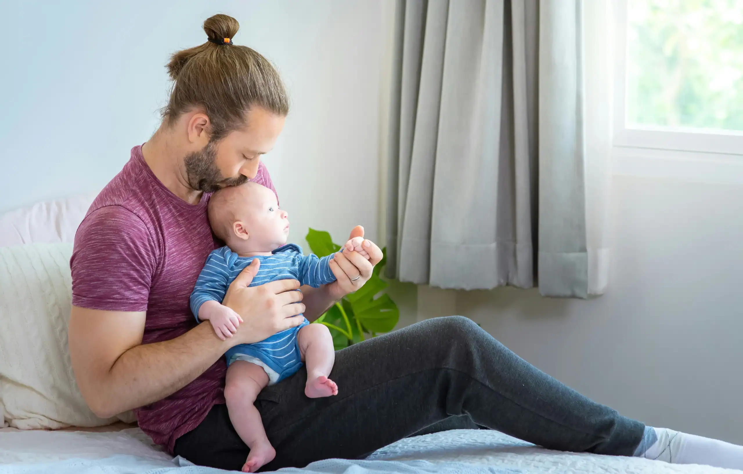 Father holding infant after tongue and lip tie treatment