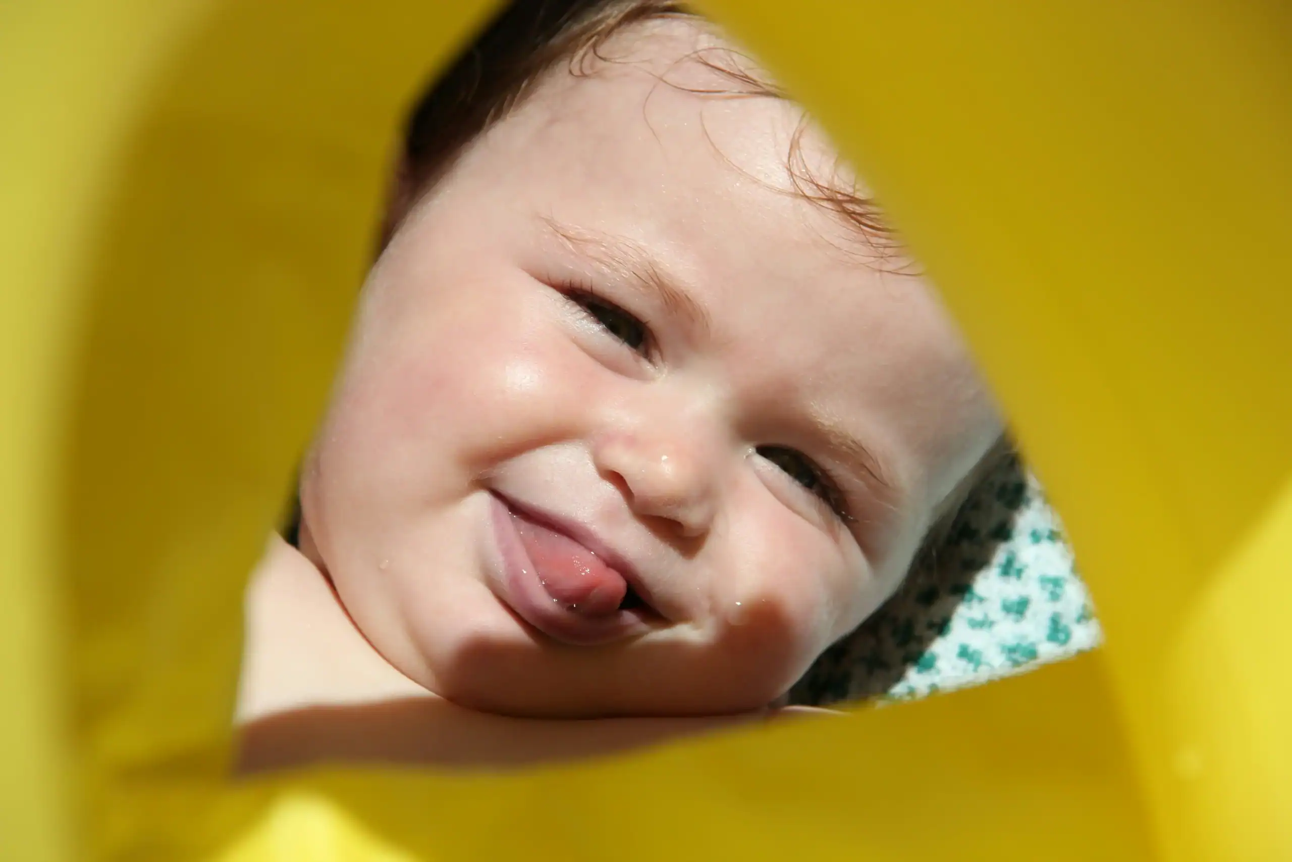 Smiling baby showing tongue with signs of tongue and lip tie