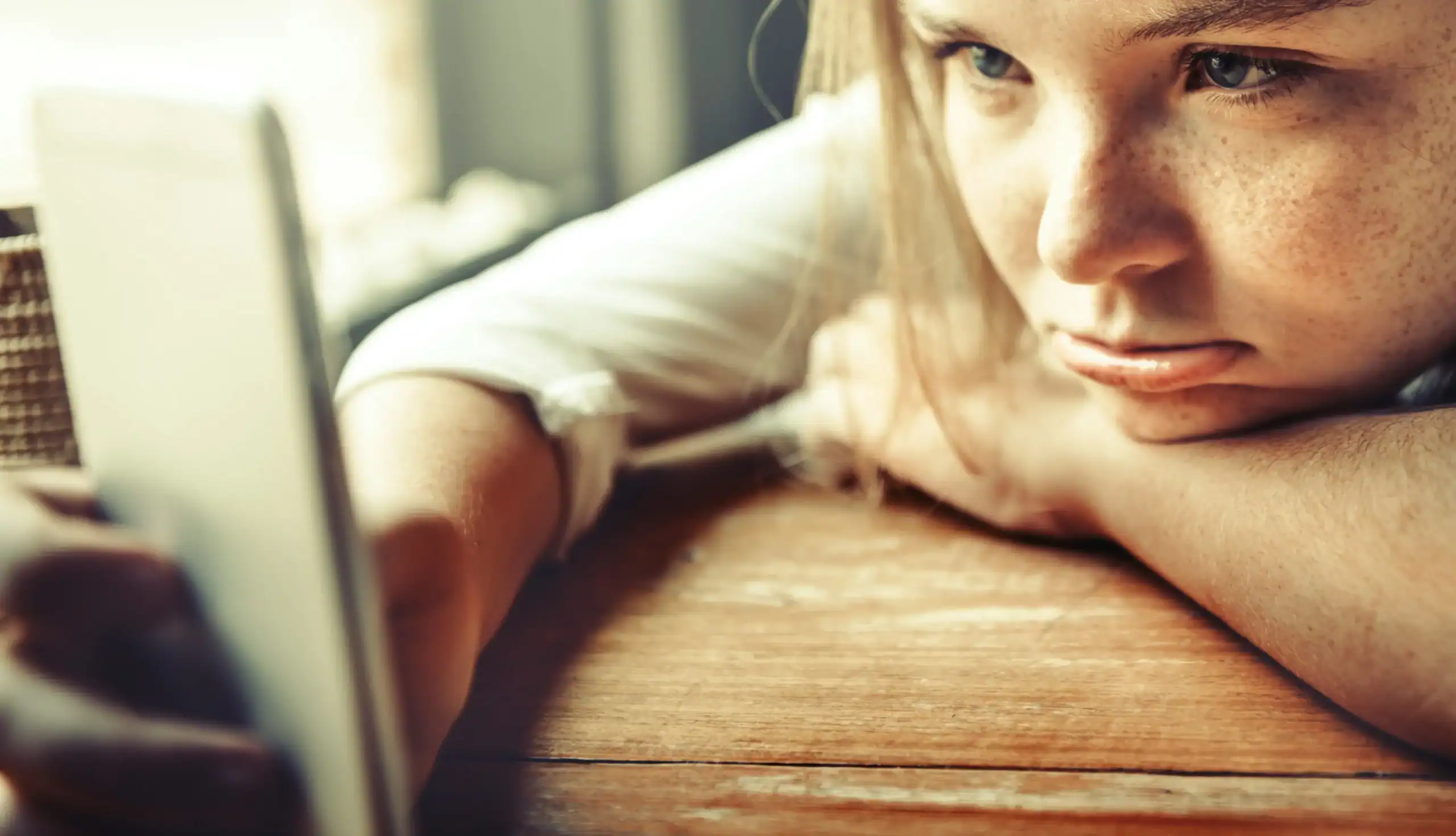 Child experiencing autism and boredom while staring at a phone with low energy. Child experiencing autism and boredom while staring at a phone with low energy.