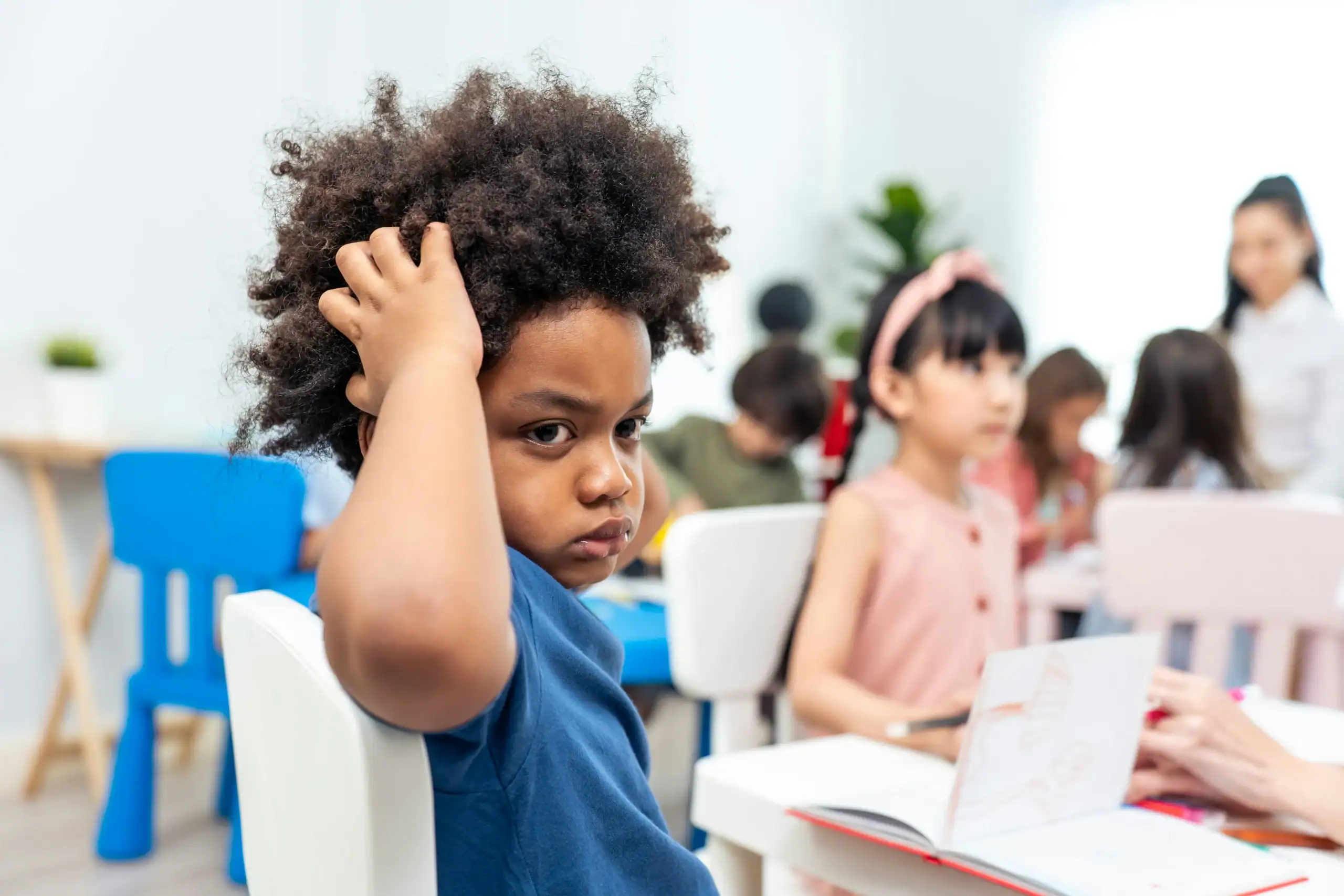 Child looking confused in classroom, illustrating what is social confusion in school settings. Child looking confused in classroom, illustrating what is social confusion in school settings.