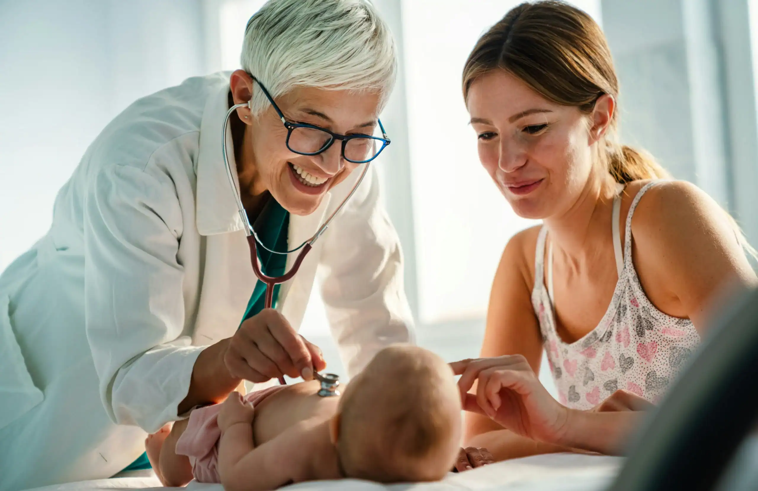 Healthcare provider examining an infant with parent present, monitoring early signs of autism in newborns Healthcare provider examining an infant with parent present, monitoring early signs of autism in newborns